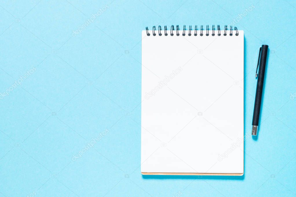Notebook and pen on blue background.
