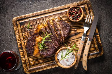 Izgara dana biftek orta ahşap kesme tahtası üzerinde.