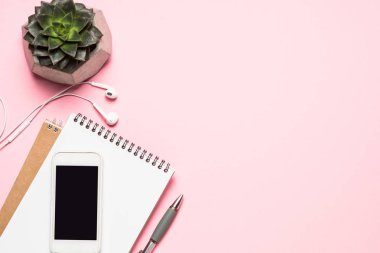 Ev Ofis İşyeri ile akıllı telefon, klavye ve kaktüs üzerinde pembe üstten görünüm. 