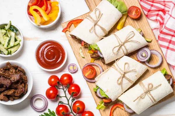 Burritos tortilla wraps med nötkött och grönsaker på vit. — Stockfoto