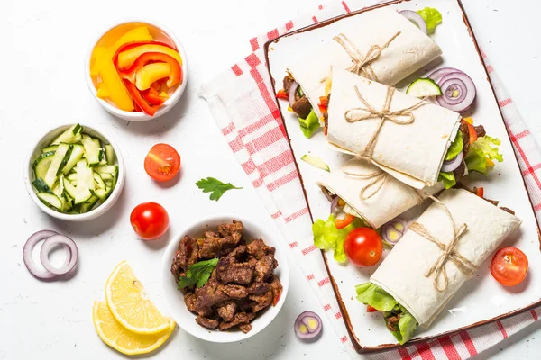 Burritos tortilla wraps med nötkött och grönsaker på vit. — Stockfoto