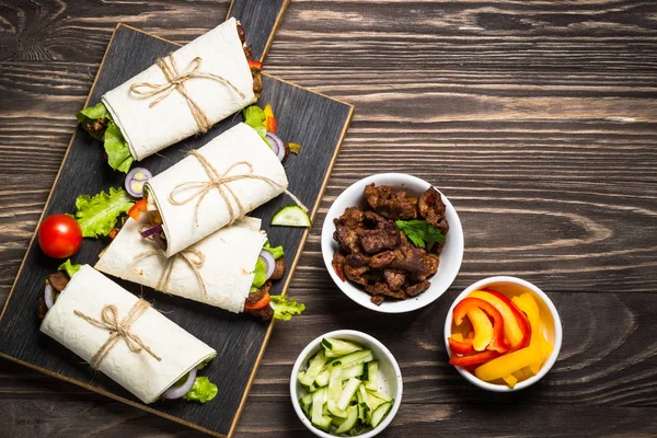 Burritos tortilla wraps med nötkött och grönsaker ovanifrån. — Stockfoto