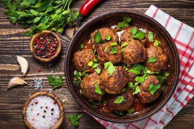 Ahşap masa üstüne domates soslu köfte görüntülemek. 