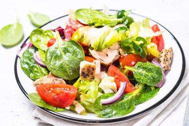 Beyaz üzerinde tavuk ve sebze ile yeşil salata.