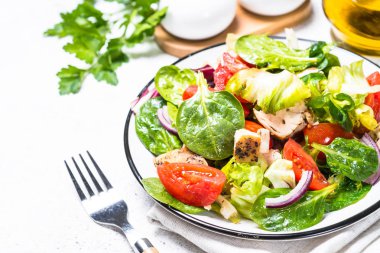 Beyaz üzerinde tavuk ve sebze ile yeşil salata.