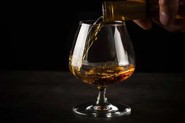 Brandewijn of cognac in het glas gieten. — Stockfoto