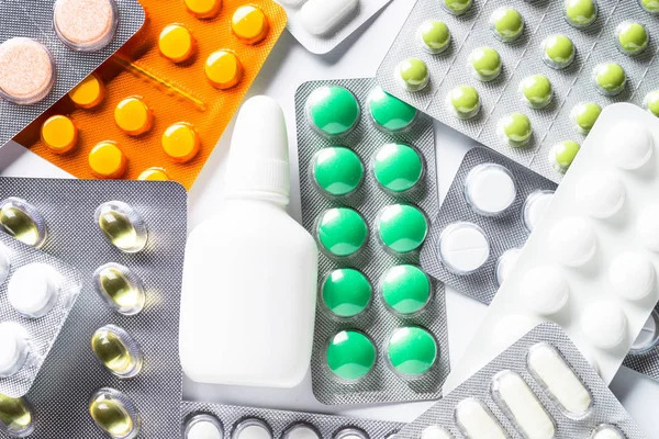 Pastillas en una ampolla y vitaminas sobre fondo blanco flatlay . — Foto de Stock