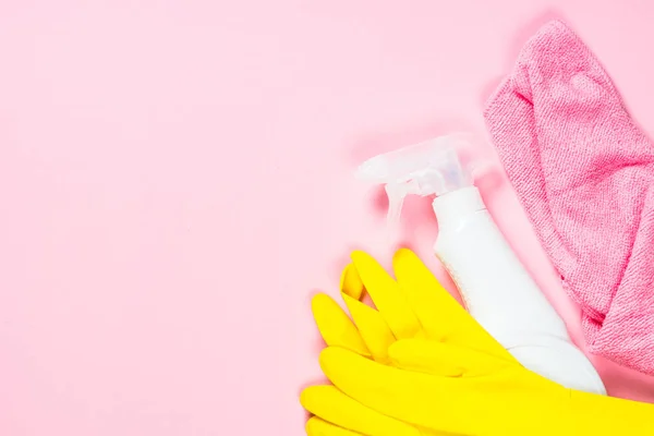 Pulizia spray, panno e guanti su sfondo rosa . — Foto Stock