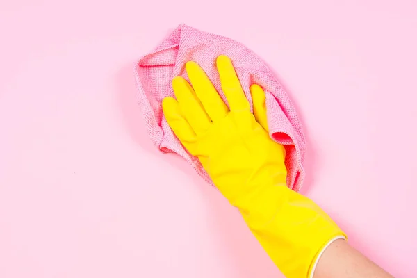 Mano en guantes amarillos y trapo de microfibra limpieza fondo rosa . —  Fotos de Stock
