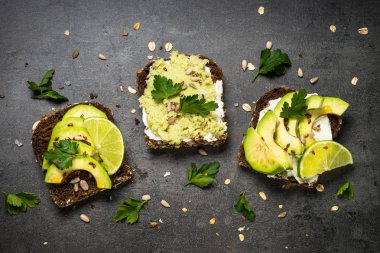 Siyah üzerinde avokado ile sandviçler.