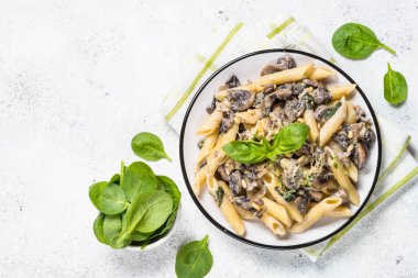 Beyaz üzerinde mantar ve ıspanak ile makarna.