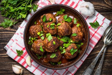 Ahşap masa üstüne domates soslu köfte görüntülemek. 