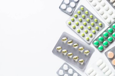 Bir blister ve beyaz arka plan flatlay vitamin hapları.