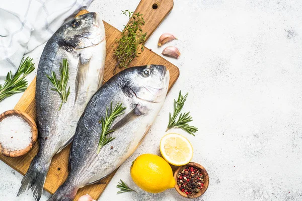 Peixe dorado cru sobre tábua de corte na mesa . — Fotografia de Stock