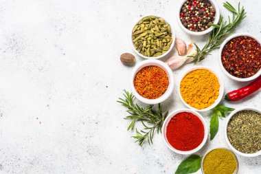 Beyaz taş masada baharatlar ve otlar.
