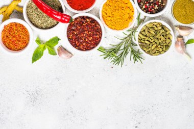 Beyaz taş masada baharatlar ve otlar.