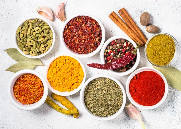 Färgade indiska kryddor på vitt bord. — Stockfoto