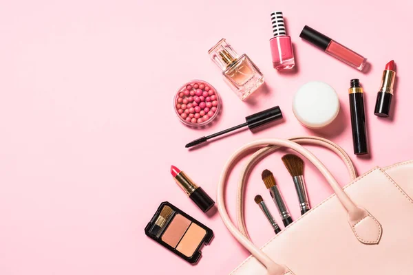 Vrouw plat lay make-up achtergrond met cosmetica op roze. — Stockfoto