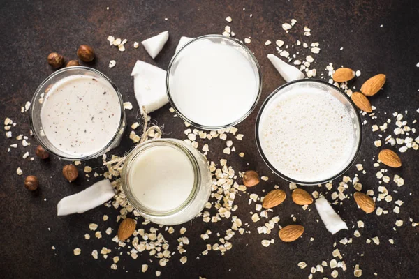 Vegansk alternativ melk, ikke melkeprodukter, på mørkerødt bord . – stockfoto