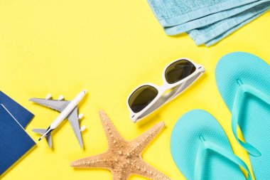 Mavi flip flop, güneş gözlüğü, pasaport ve Sarı zemin üzerine deniz yıldızı.
