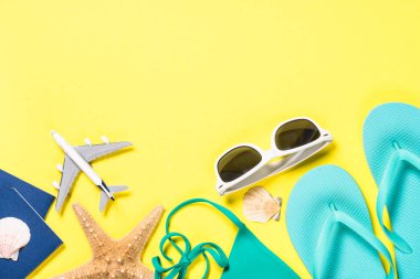 Mavi flip flop, Mayo, güneş gözlüğü ve Sarı zemin üzerine deniz yıldızı.