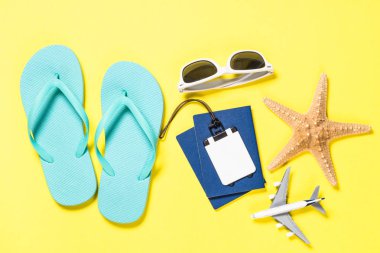 Mavi flip flop, güneş gözlüğü, pasaport ve Sarı zemin üzerine deniz yıldızı.