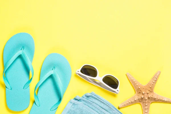 Blå flip flops, solglasögon och sjöstjärnor på gul bakgrund. — Stockfoto