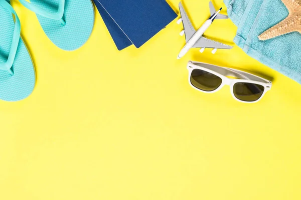 Blå flip flops, solglasögon, pass och sjöstjärnor på gul bakgrund. — Stockfoto
