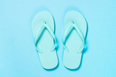 Mavi arka planda mavi parmak arası terlikler.
