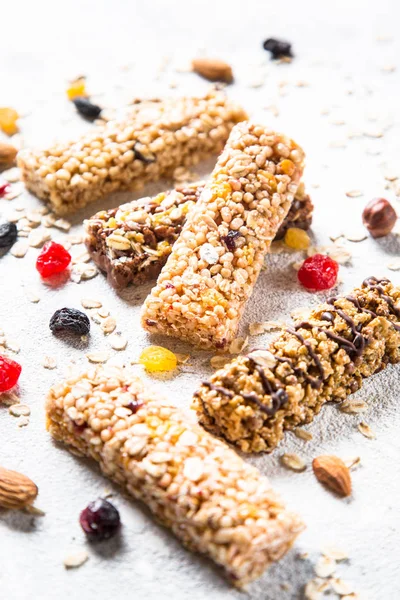 Granola bar with nuts, fruit and berries on white.