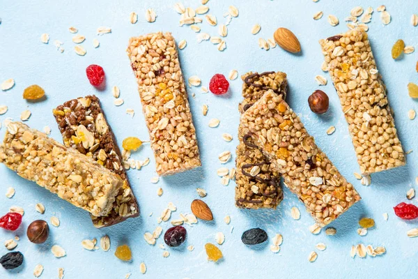 Granola bar with nuts, fruits and berries on blue.