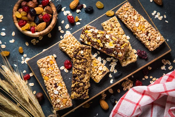 Granola bar with nuts, fruit and berries on black. — Stock Photo, Image