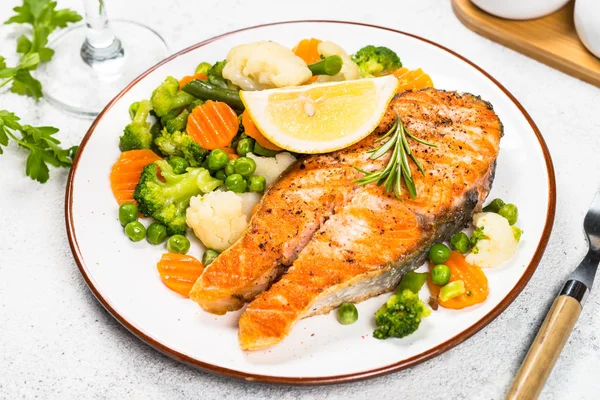 Grilled salmon steak with vegetables on white. — Stock Photo, Image