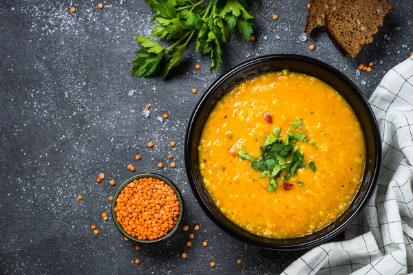 Red lentil soup on black top view. — Stock Photo, Image