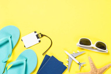 Mavi flip flop, güneş gözlüğü, pasaport, uçak ve Sarı zemin üzerine deniz yıldızı.