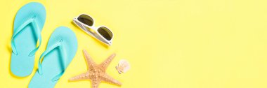 Mavi flip flop, Mayo, güneş gözlüğü ve Sarı zemin üzerine deniz yıldızı.