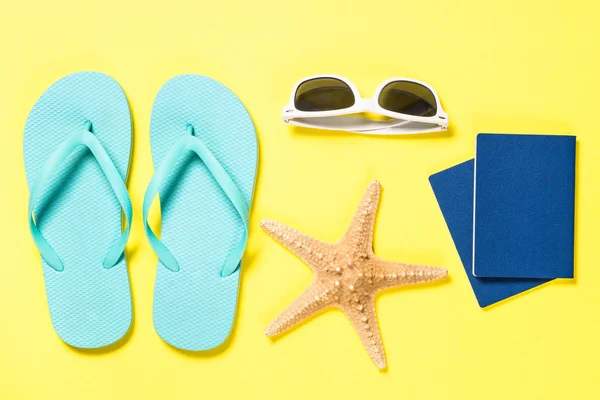 Blå flip flops, solglasögon, pass och sjöstjärna på gult. — Stockfoto
