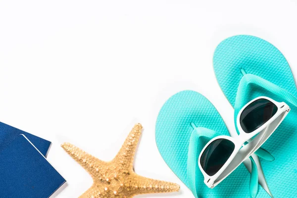 Blue flip flops, sunglasses, passport and starfish on white background. — Stock Photo, Image