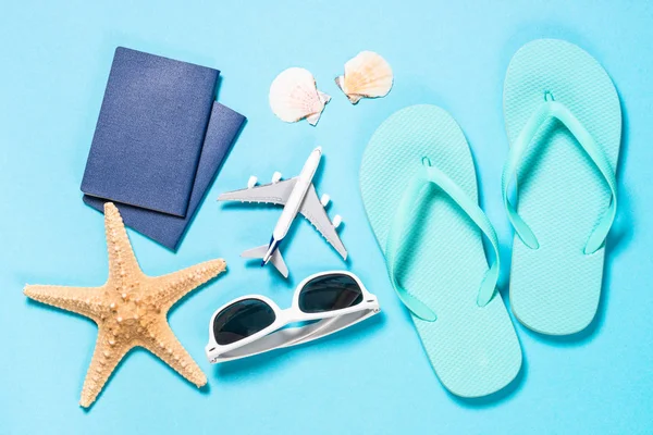 Blue flip flops, sunglasses and starfish on blue background. — Stock Photo, Image
