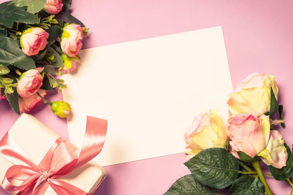 Folha de papel vazia e flores no fundo rosa . — Fotografia de Stock