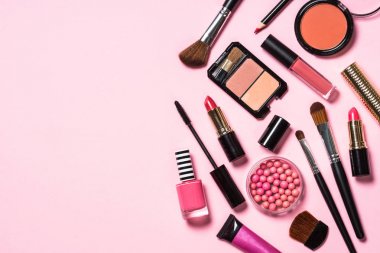 Pembe arka planda profesyonel makyaj malzemeleri.
