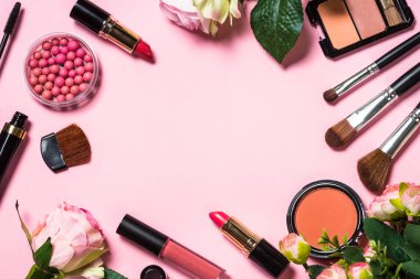 Pembe arka planda profesyonel makyaj malzemeleri.