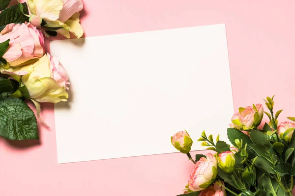 Folha de papel vazia e flores no fundo rosa . — Fotografia de Stock