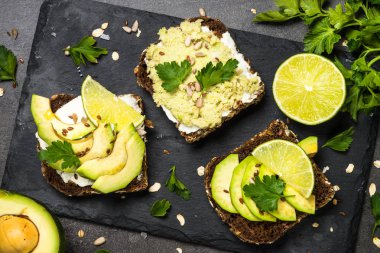 Siyah üzerinde avokado ile sandviçler.