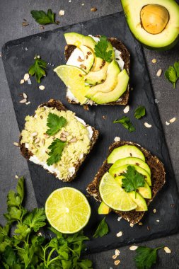 Siyah üzerinde avokado ile sandviçler.