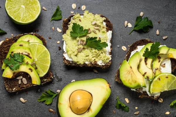 Siyah üzerinde avokado ile sandviçler.