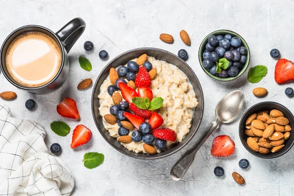 Oatmeal porridge with fresh berries and nuts top view. — Stock Photo, Image
