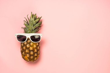 Pembe arka planda güneş gözlüğü komik ananas.