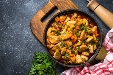 Tavuk güveç sebze siyah taş tabloyla, üstten görünüm.