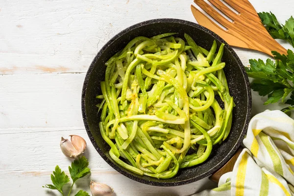 Zucchini noodles in frying pan on white. — Stock Photo, Image